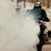 A motorcyclist trails a cloud of smoke behind him
