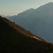 A motorcyclist riding up a steep mountain